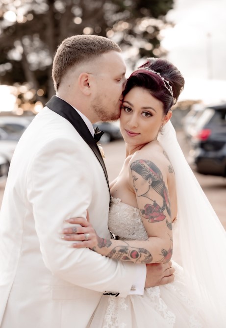 a man kissing a woman in a wedding dress