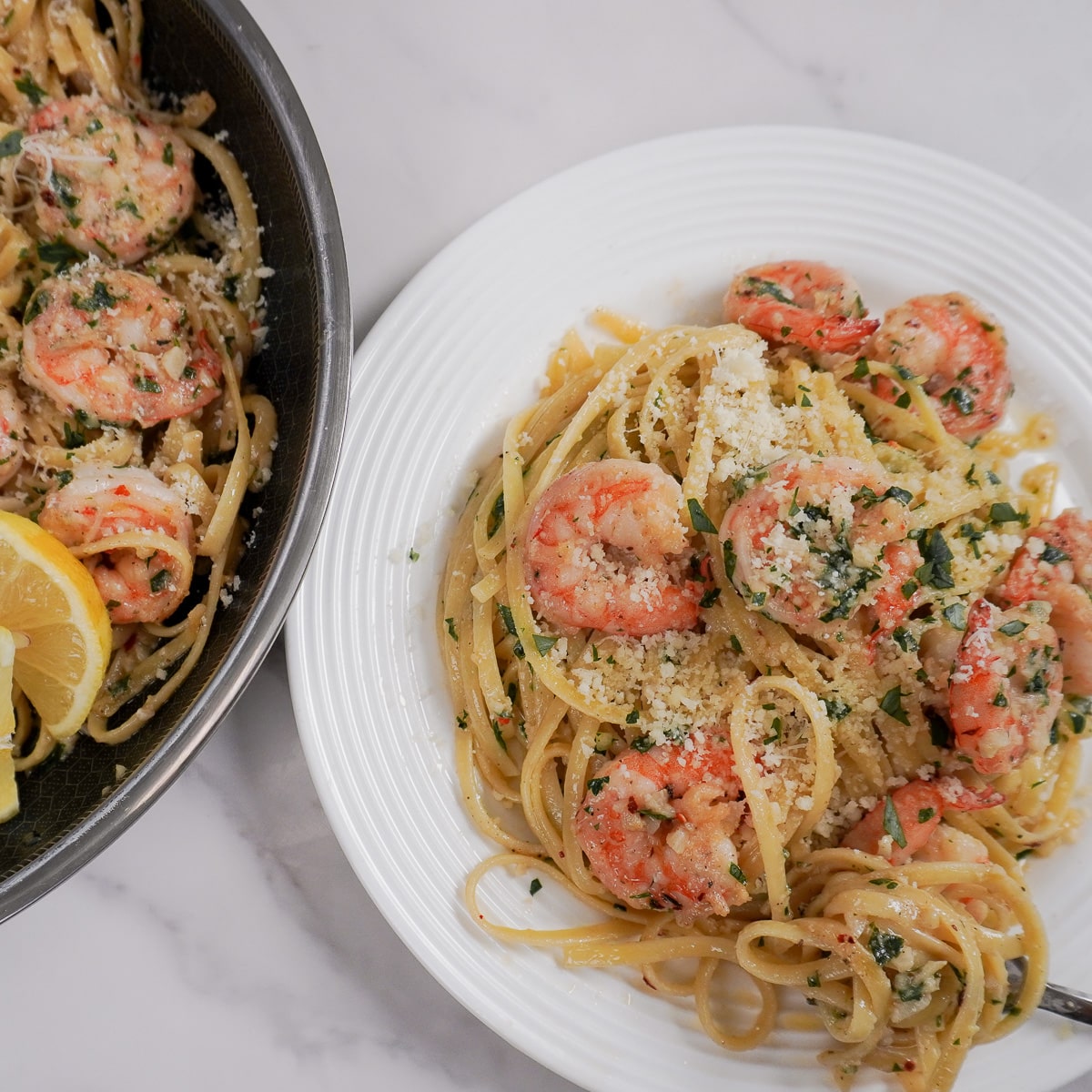 a plate of pasta with shrimp and lemon slices