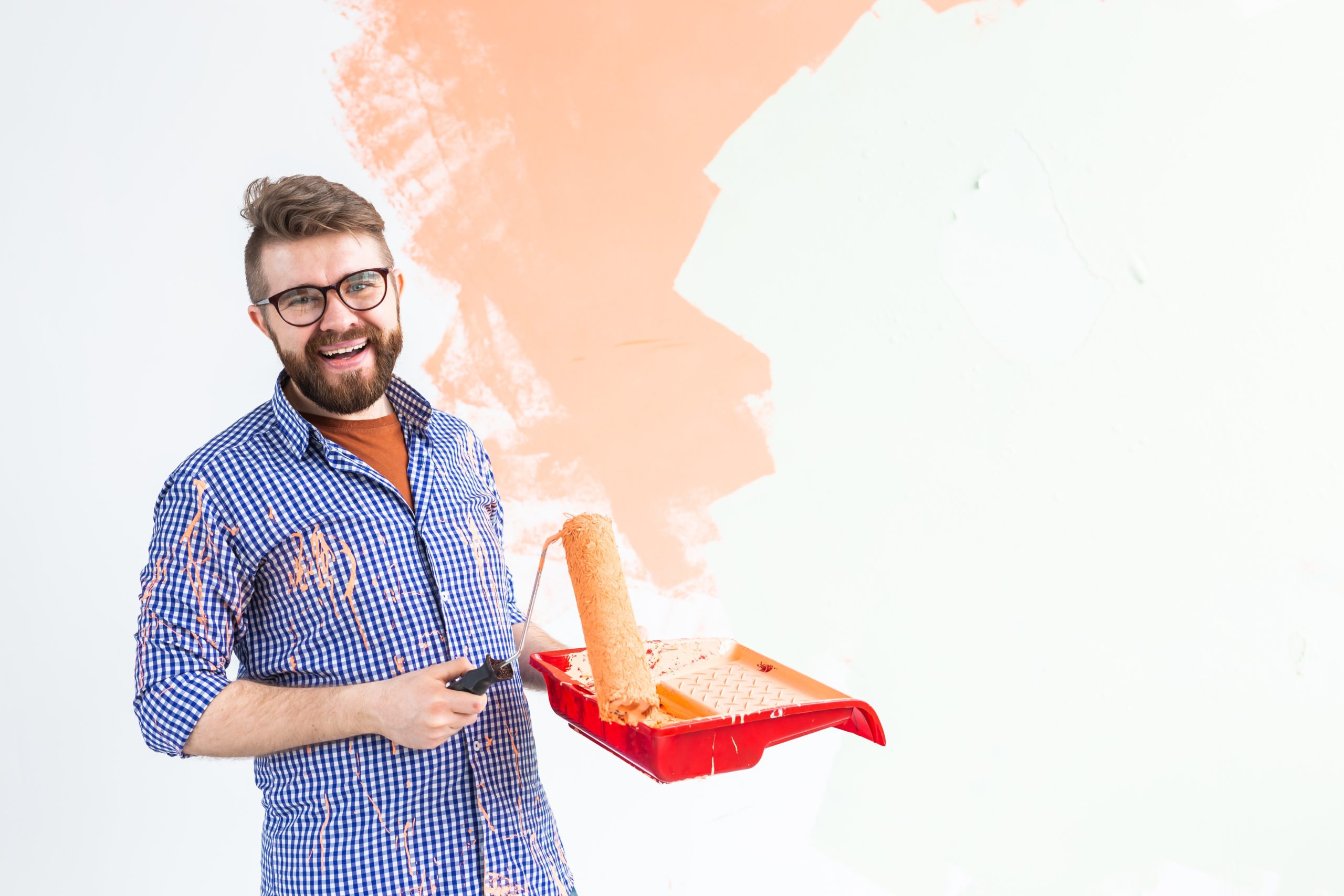 a man painting a wall with paint roller