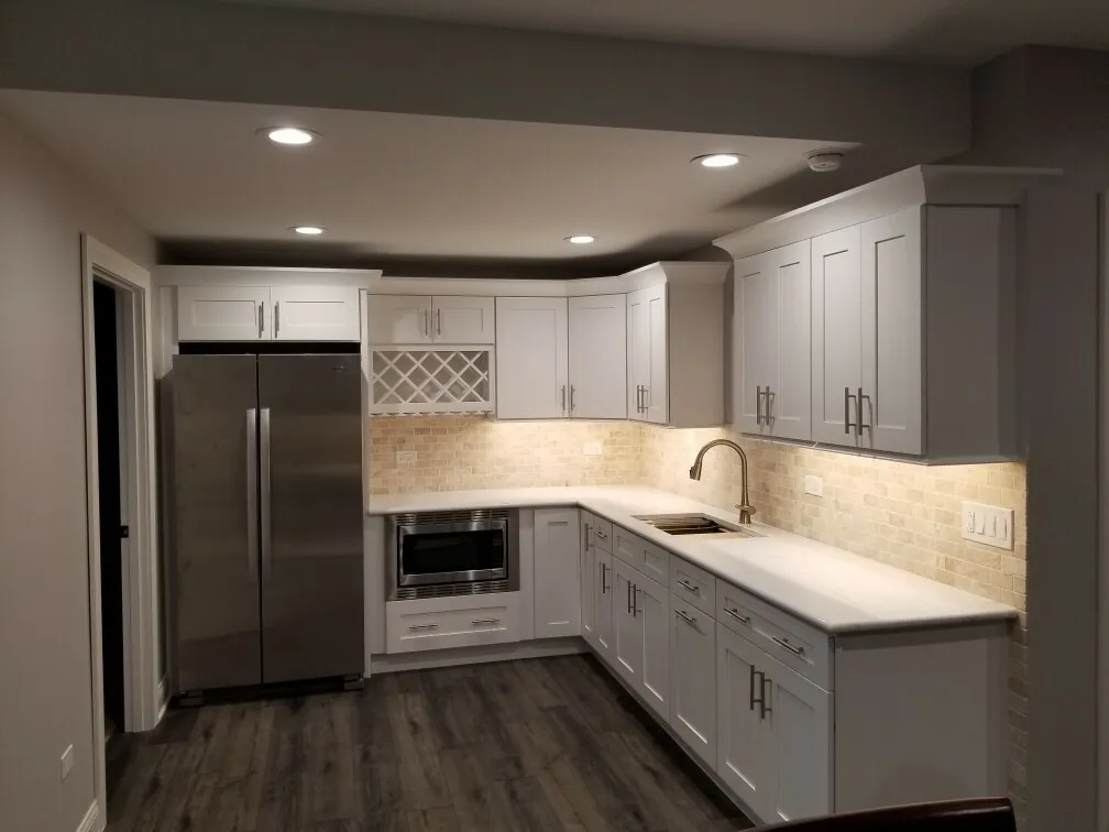 a kitchen with white cabinets and a stainless steel refrigerator