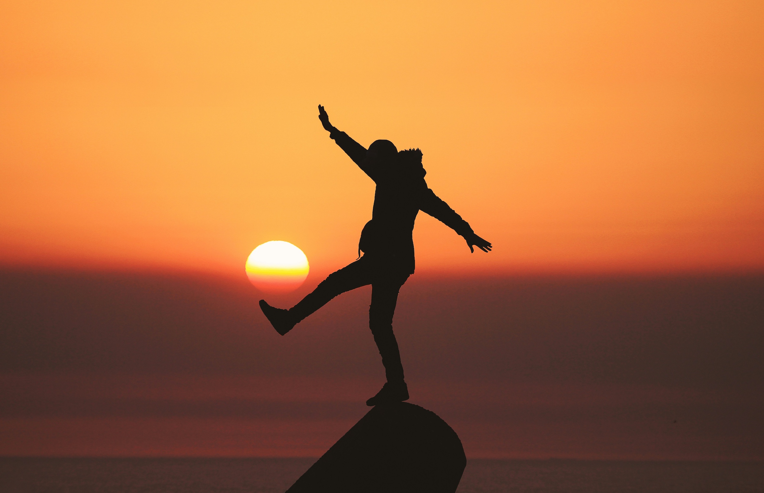 a person standing on a rock with their arms outstretched