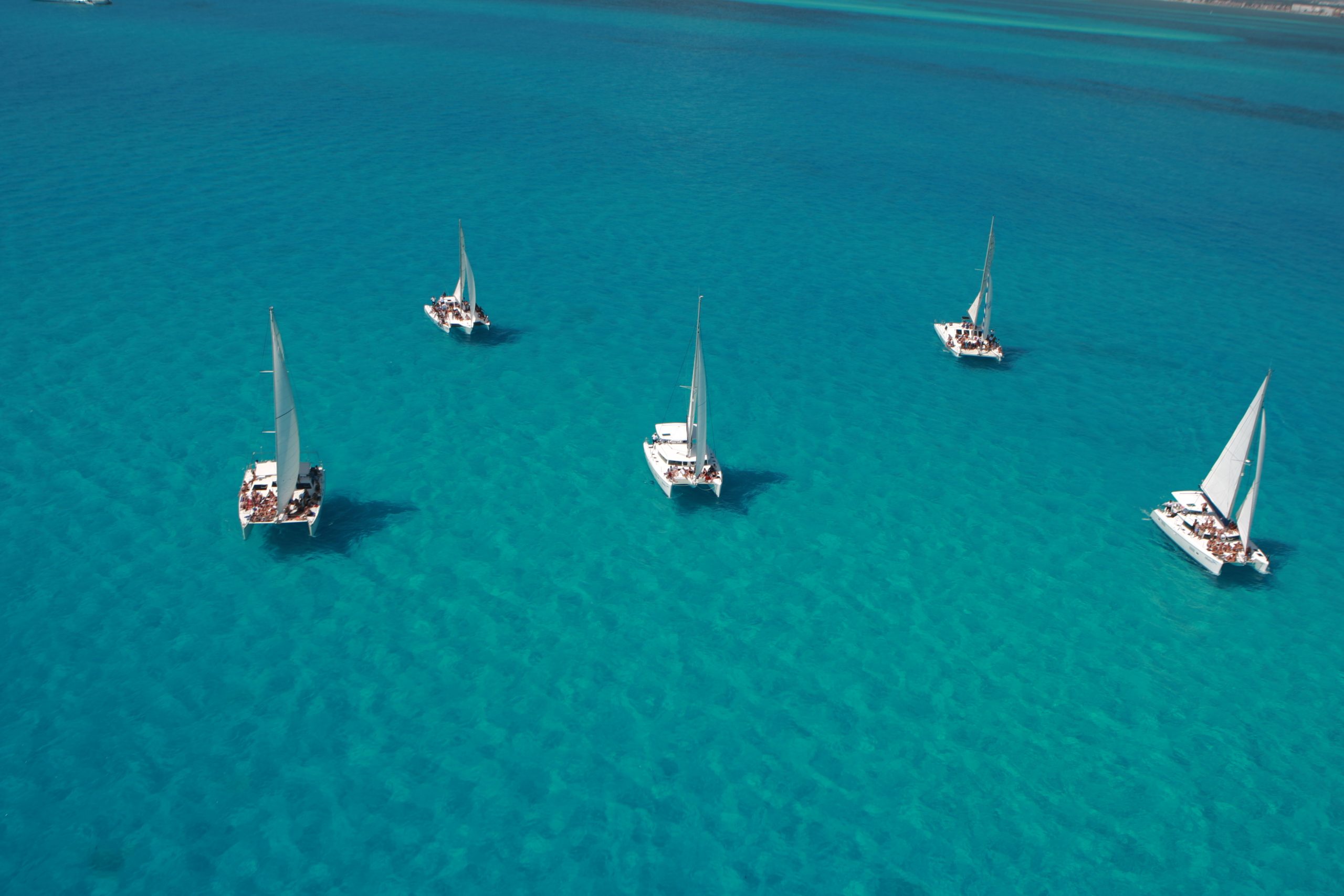 a group of sailboats in blue water