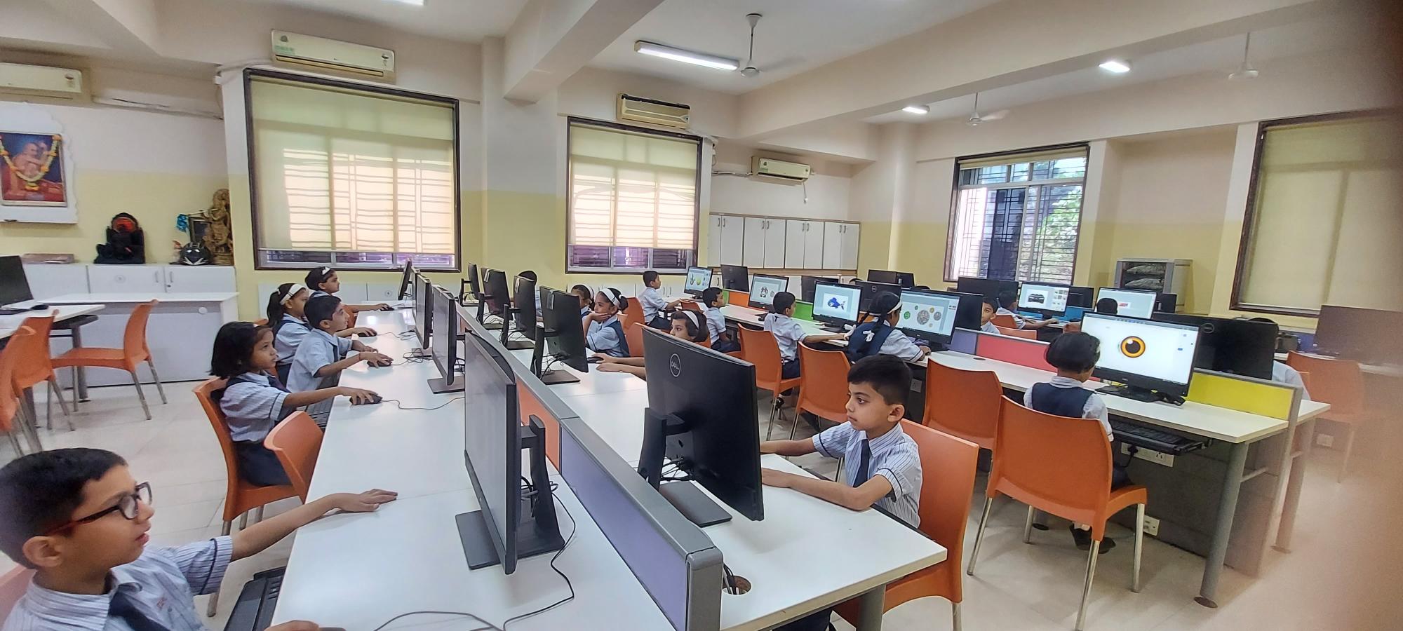 a group of children sitting at computers