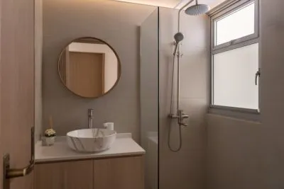 a bathroom with a round mirror and sink