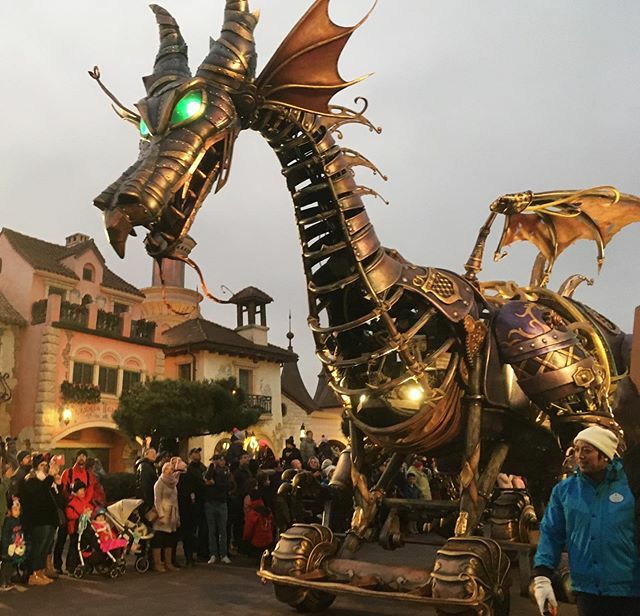 a large metal dragon with green eyes and wings