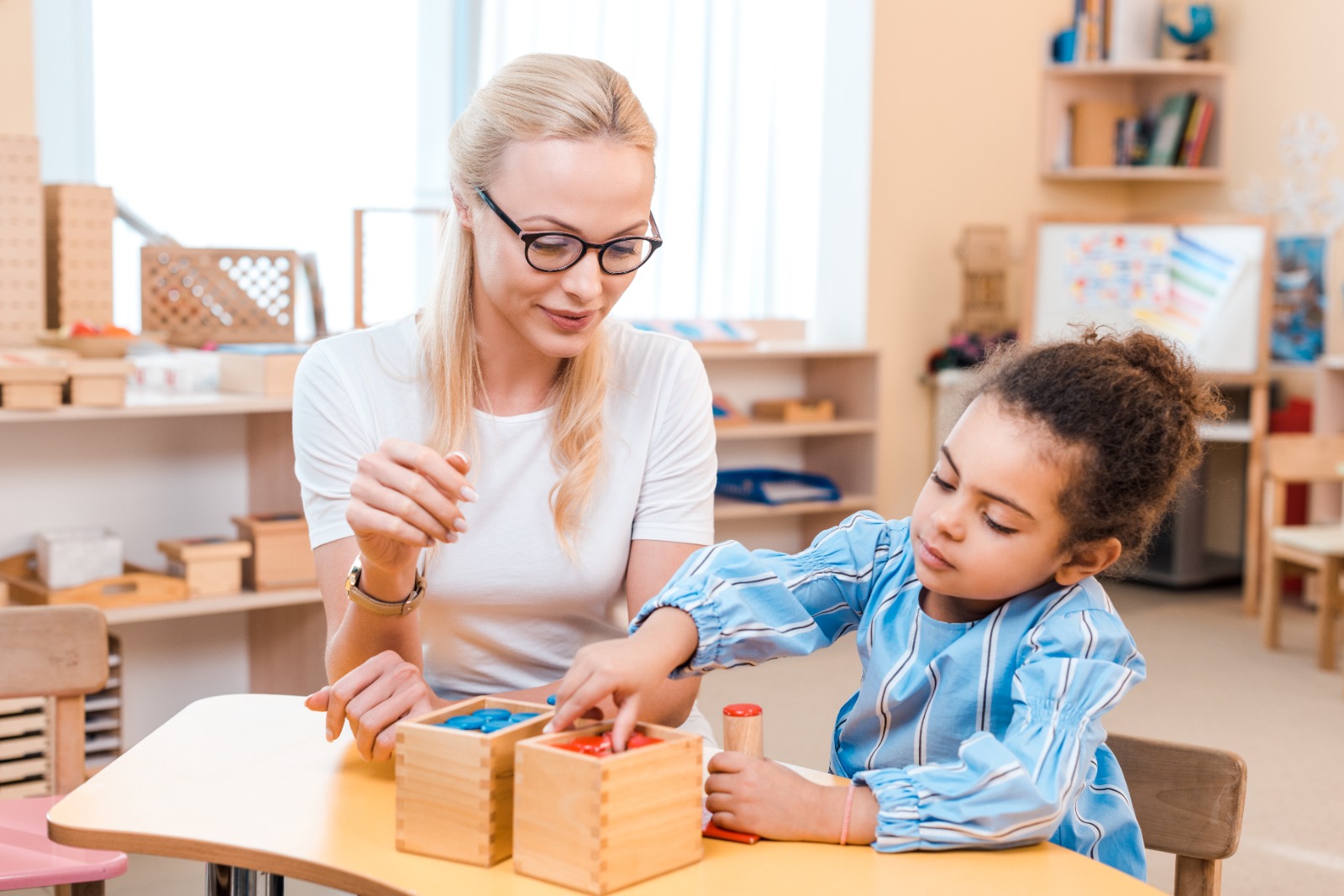 a woman and a girl playing with blocks