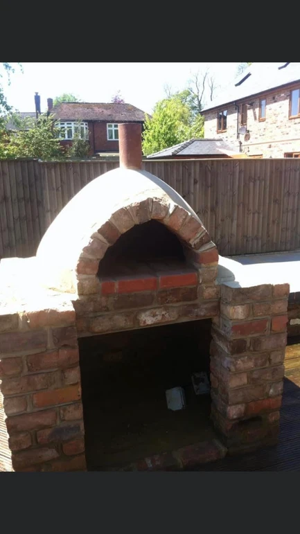 a brick oven outside with a chimney