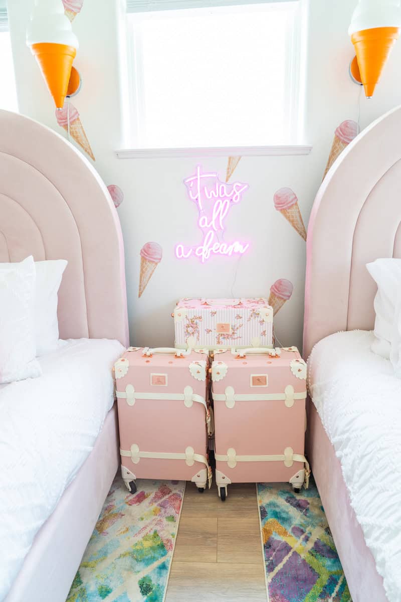 a room with pink luggage and pink pillows