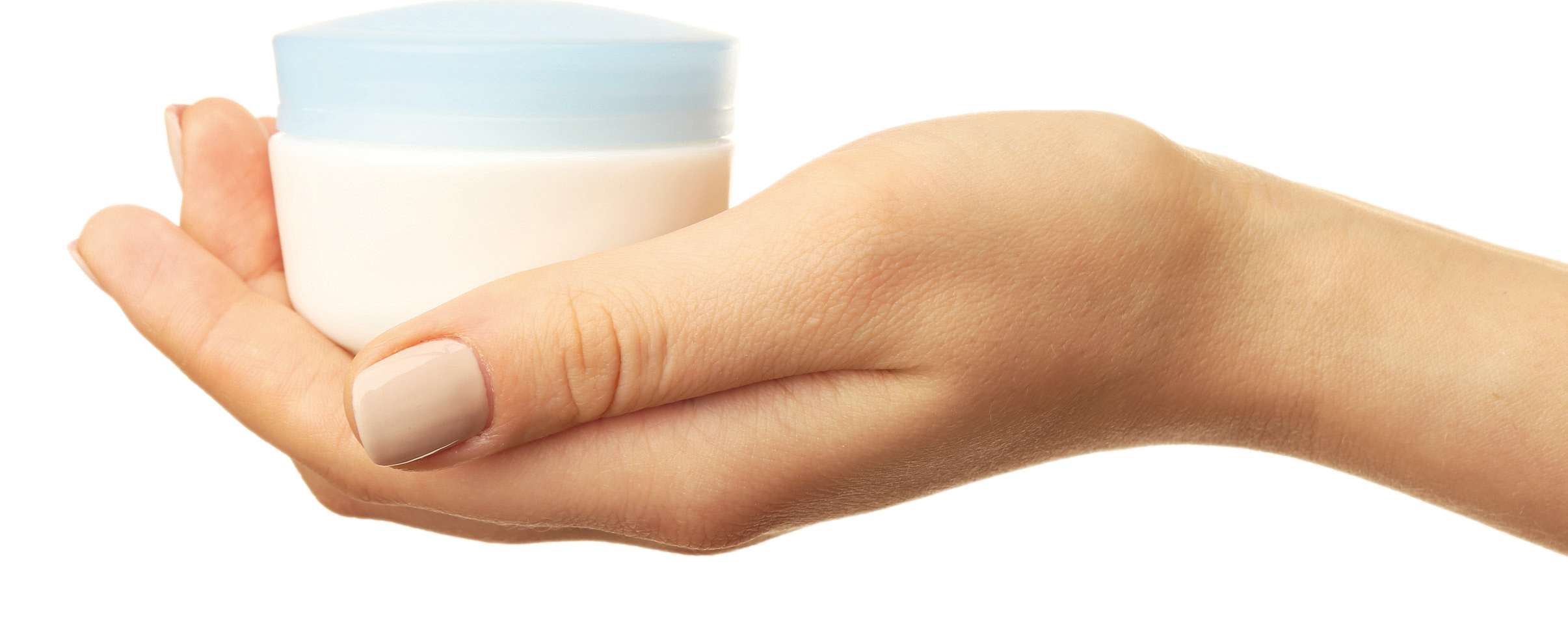 a person's hand holding a jar of cream