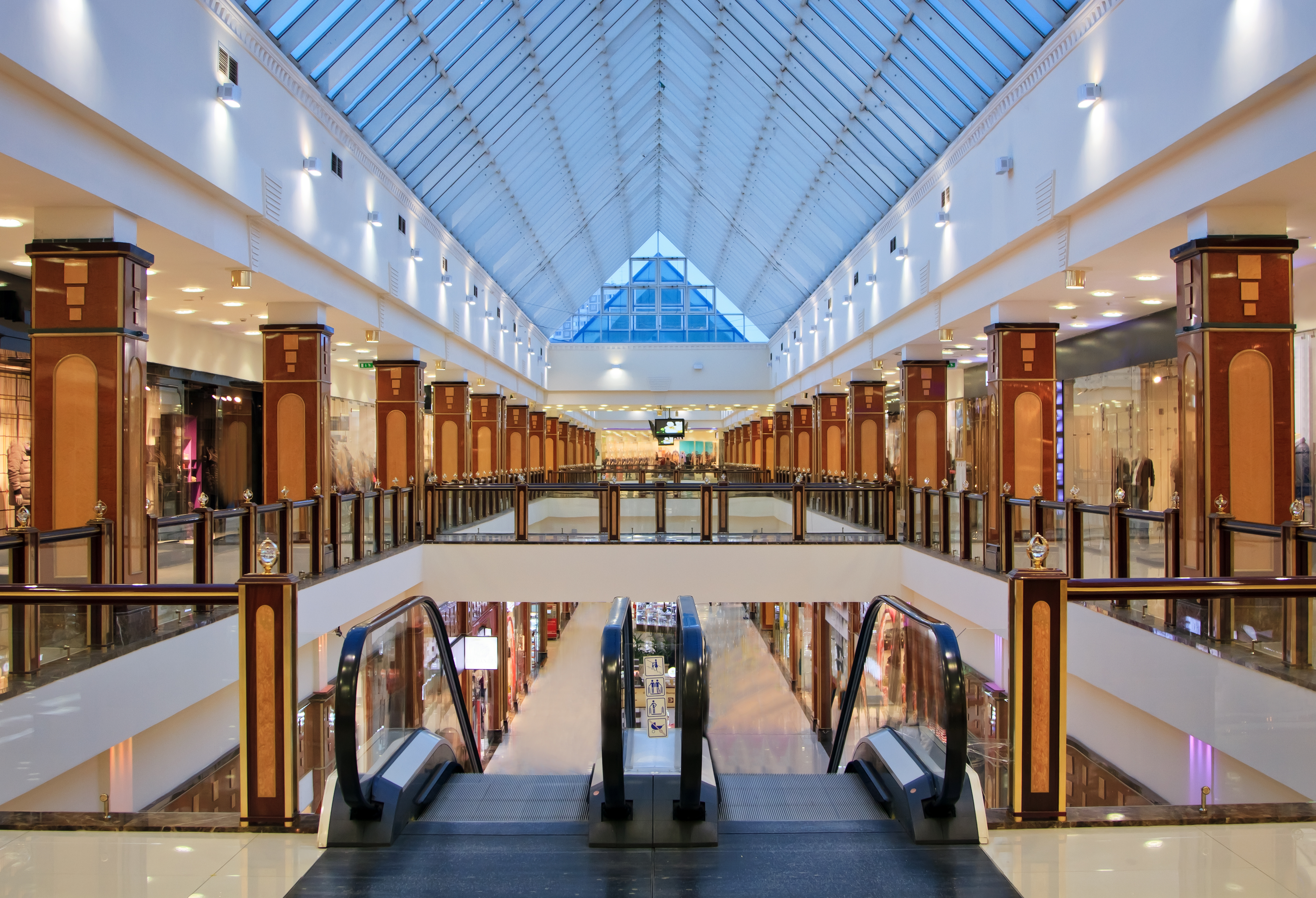 escalators inside a building with a glass roof