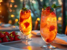 two glasses of fruit juice and strawberries on a table