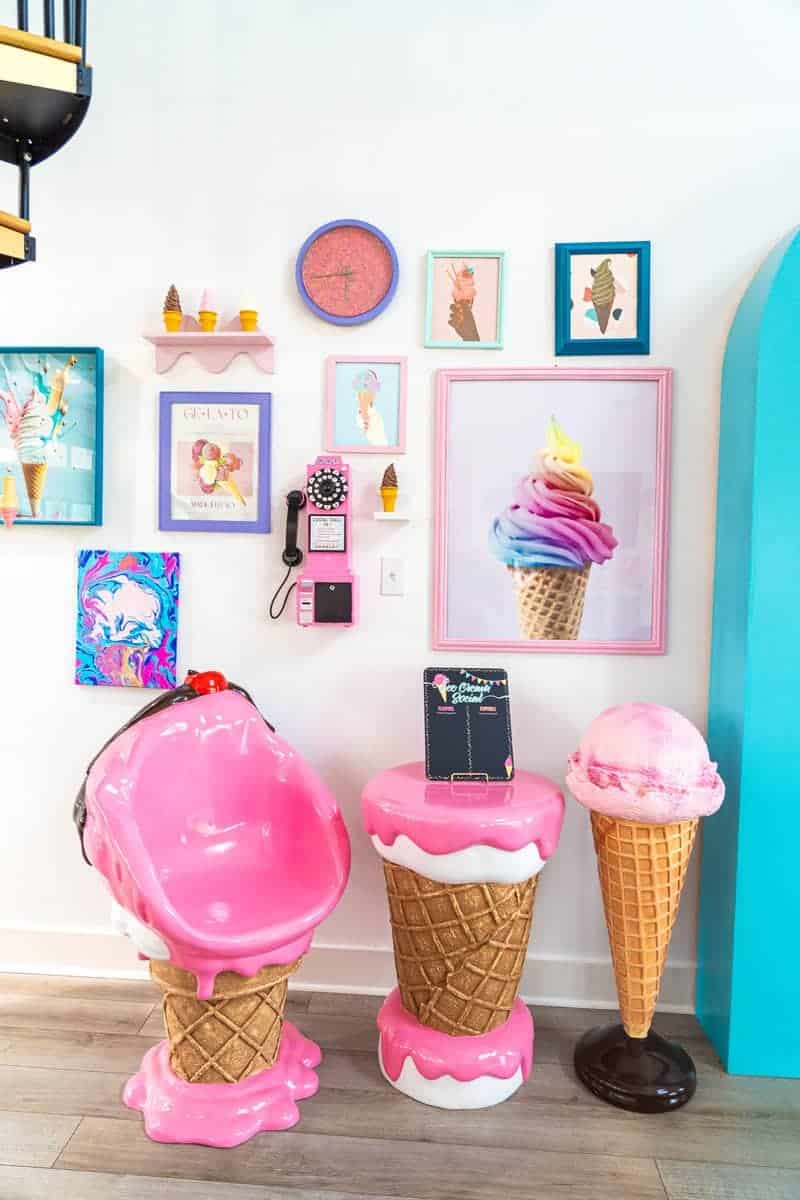 a pink ice cream chair in a room with pictures on the wall