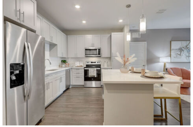 a kitchen with a stainless steel refrigerator and a white island