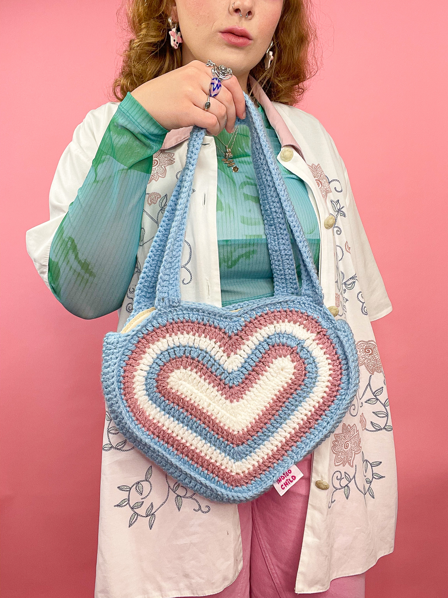 a woman holding a crochet bag