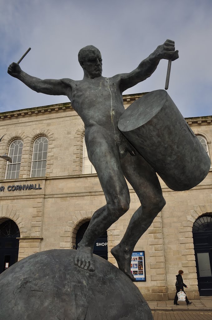 a statue of a man holding a drum and drumsticks