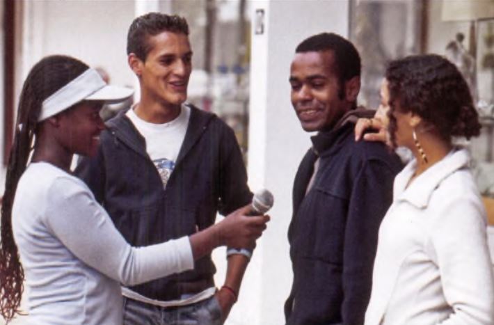 a man holding a microphone and talking to a group of people