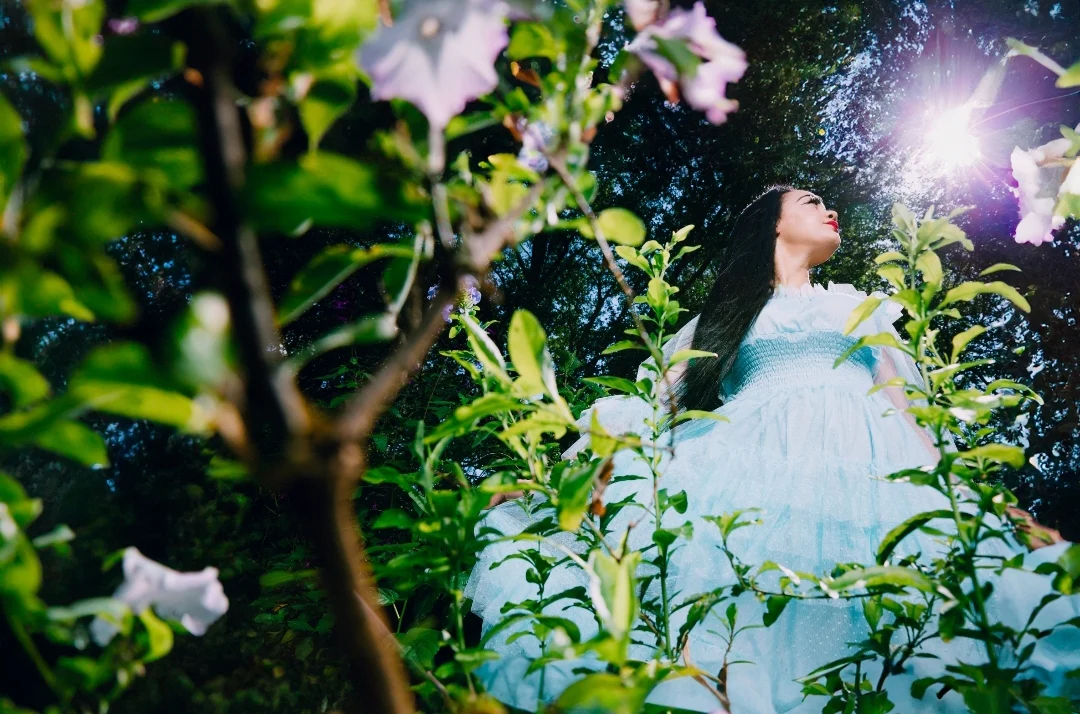a woman in a dress surrounded by plants