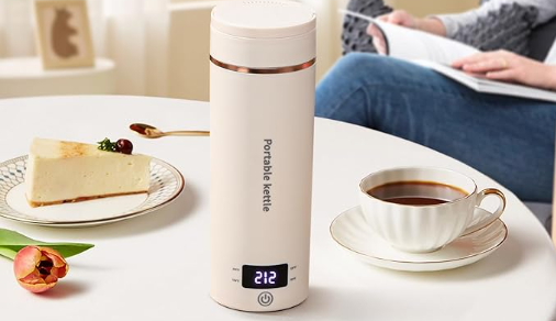 a white portable kettle on a table with a cup of coffee and a plate of food