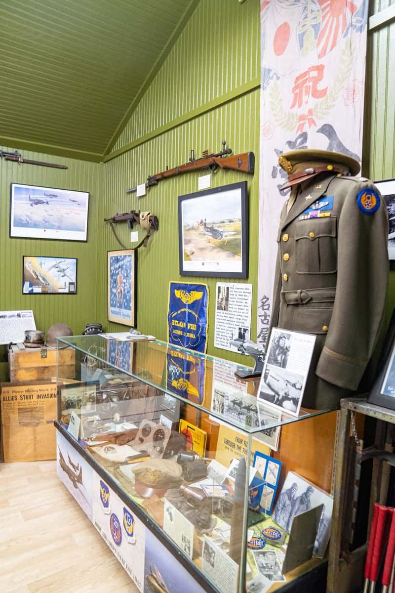 a display case with military uniform and weapons on it