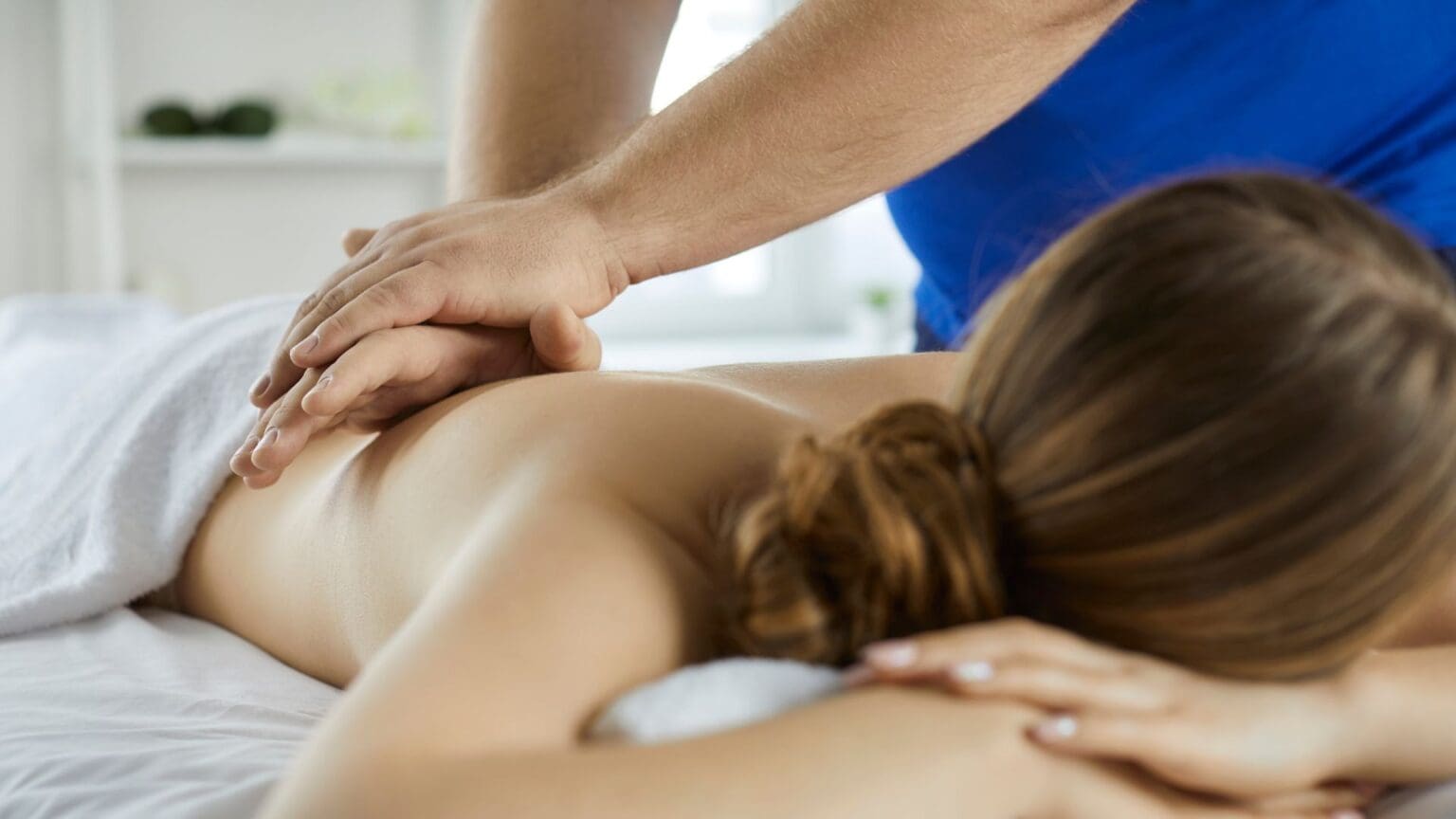 a person massaging a woman's back