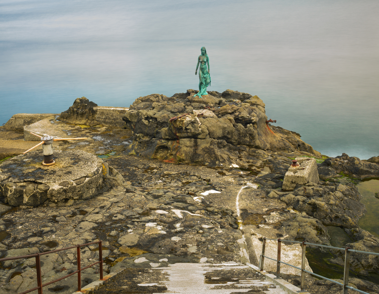 a statue on a rocky area