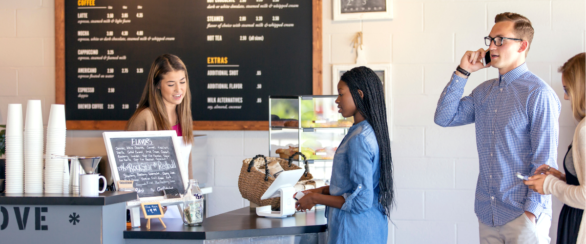 a woman standing at a counter with a woman in a blue shirt