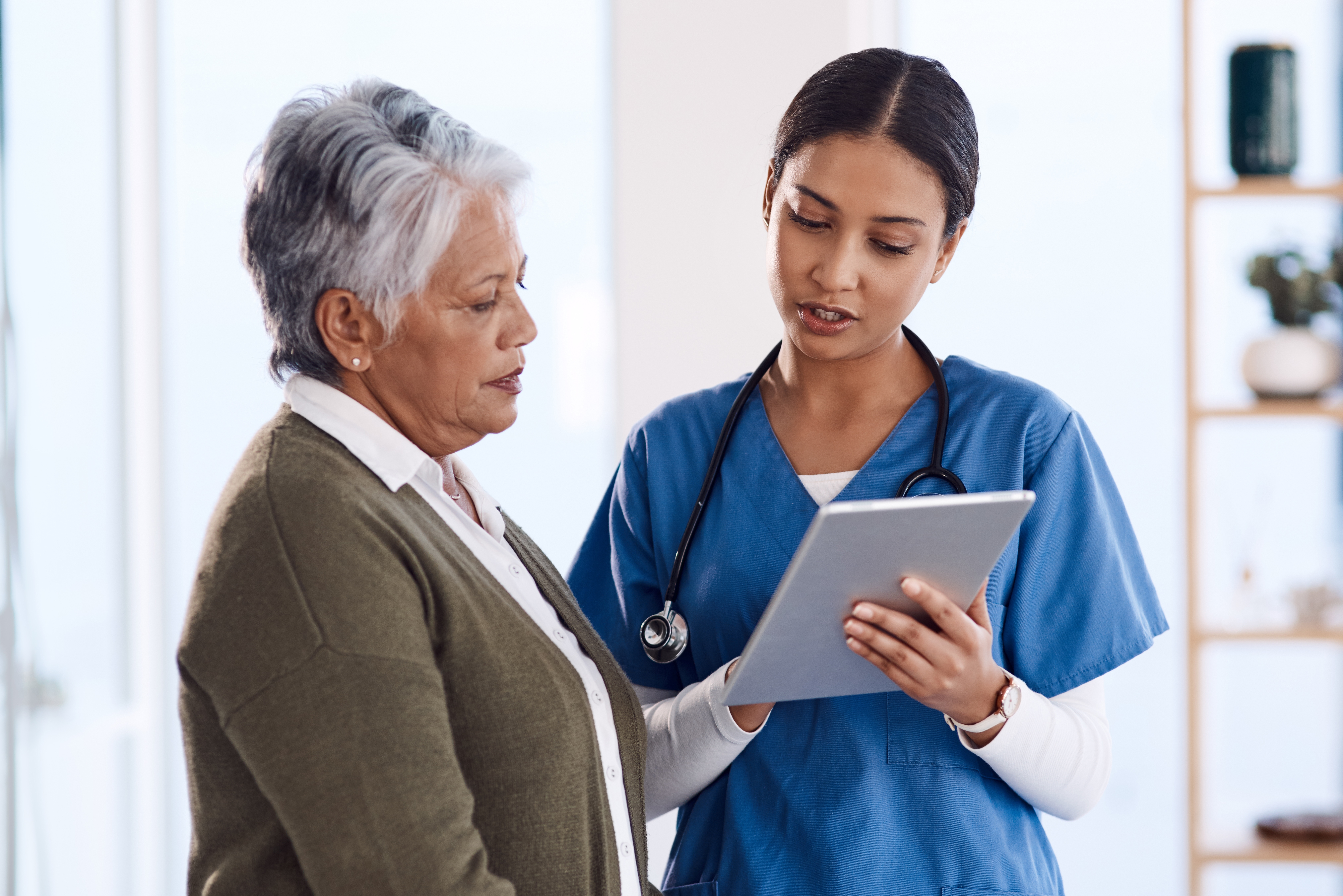 a woman and a doctor looking at a tablet