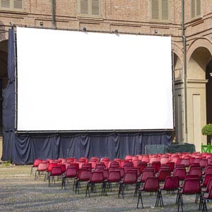 a large screen with red chairs in front of a building