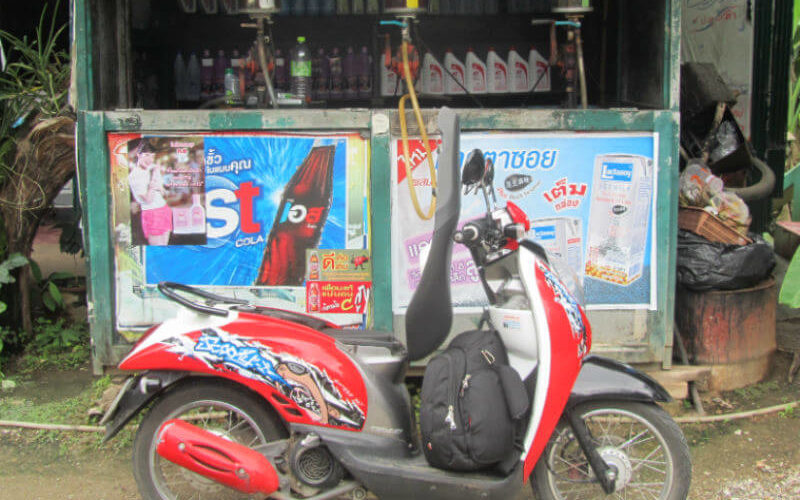 a red and black scooter with a backpack on it