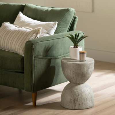 a green couch with pillows and a small round table