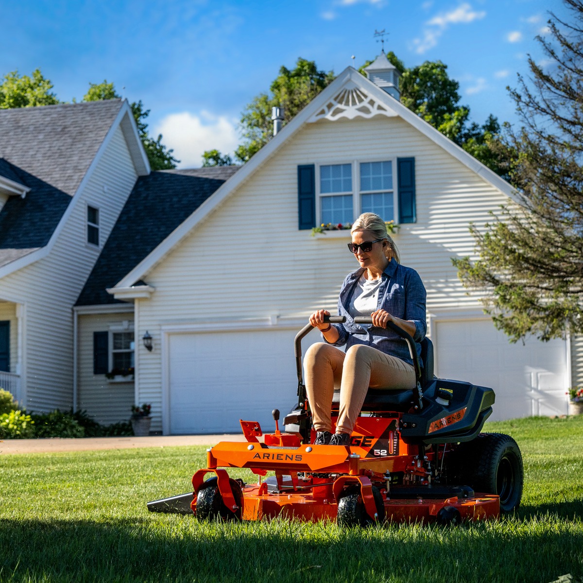 a woman riding a lawn mower in a yard