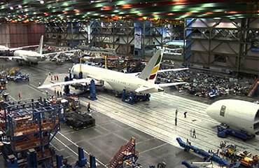 an airplane hangar with workers in the background