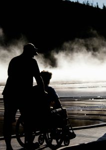 a man pushing a woman in a wheelchair