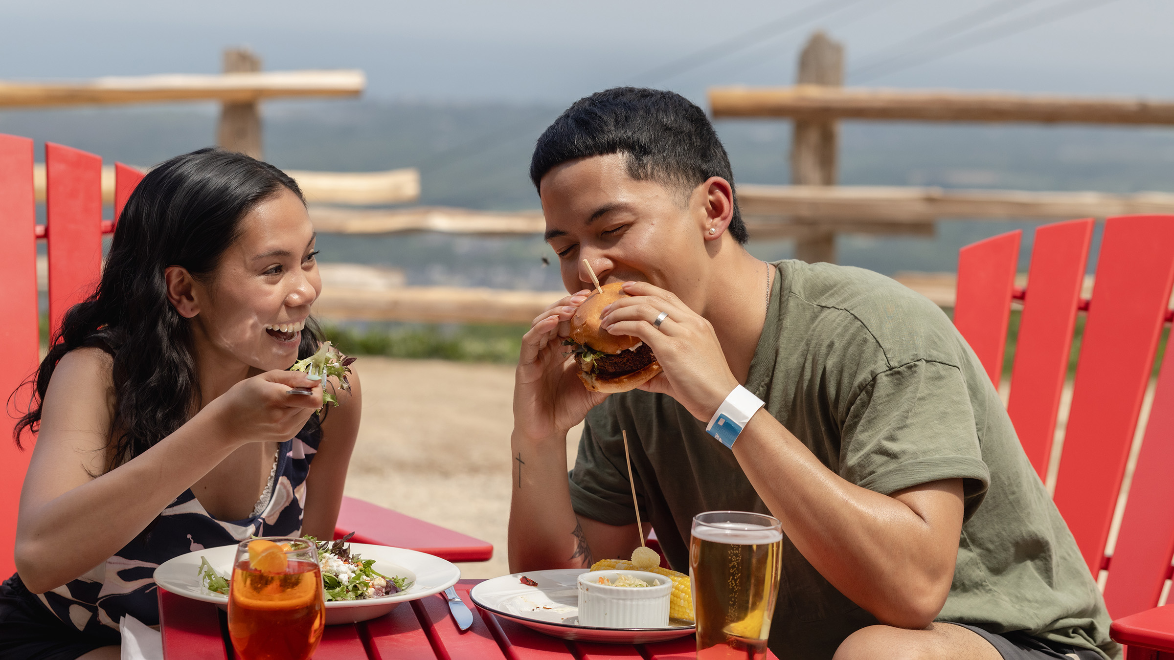 a man and woman eating burgers at a table