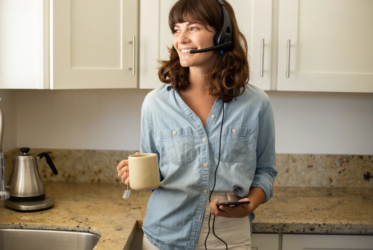 a woman with a headset and a phone and a cup