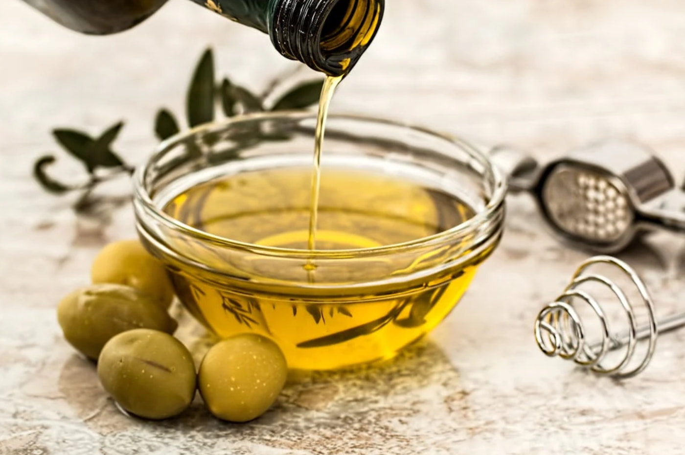 olive oil being poured into a bowl