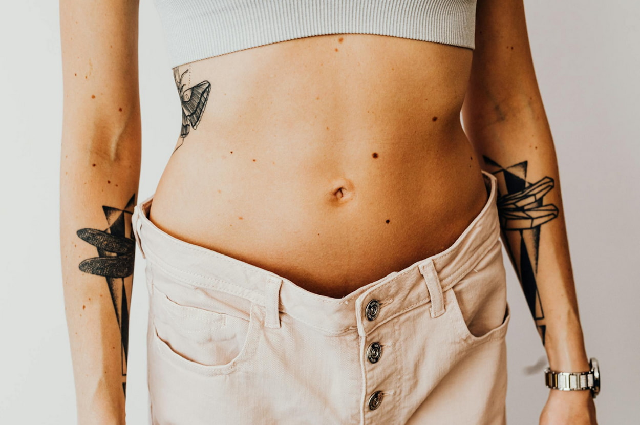 a woman's stomach with tattoos