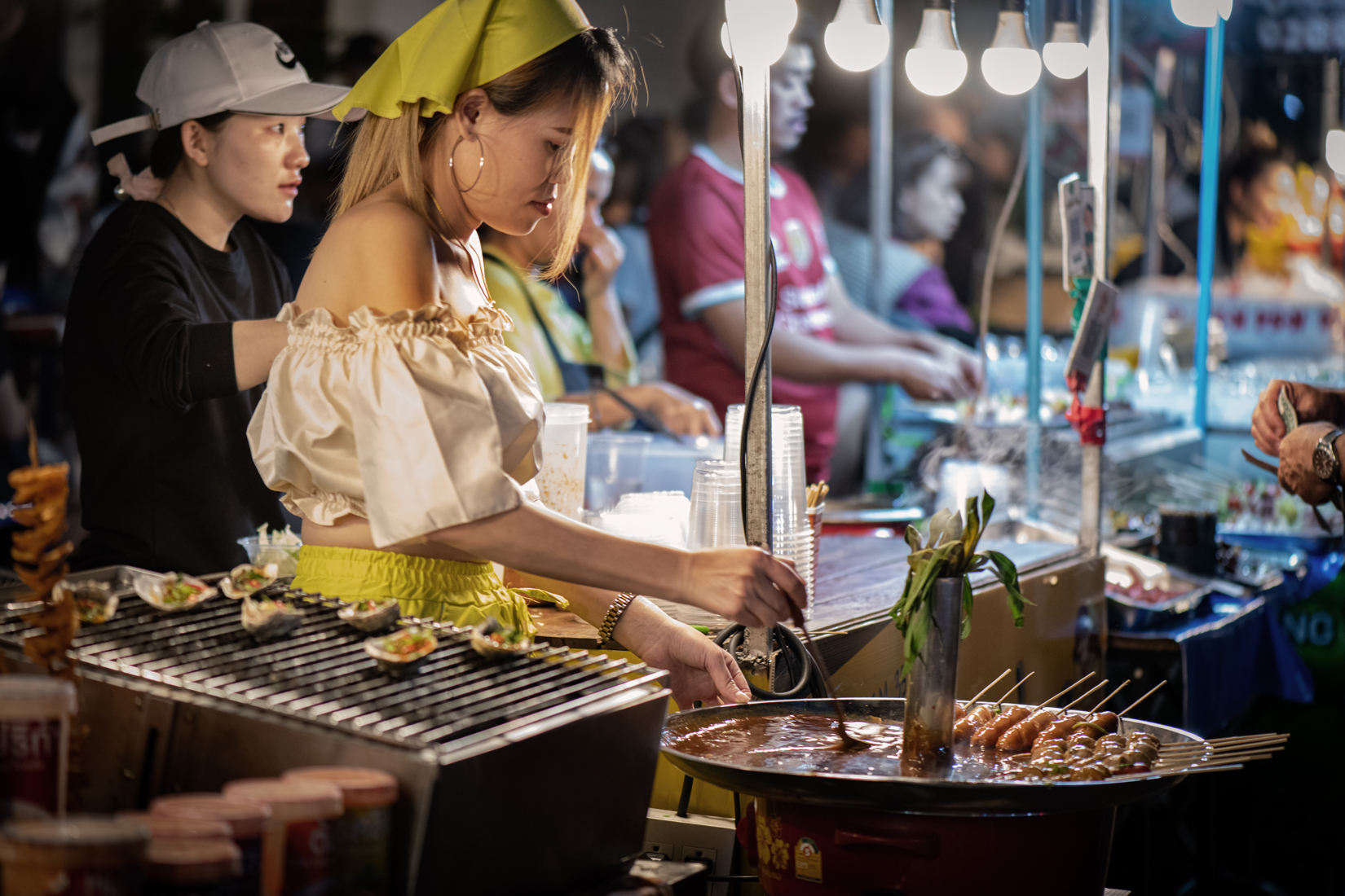 a woman cooking food at a food stand