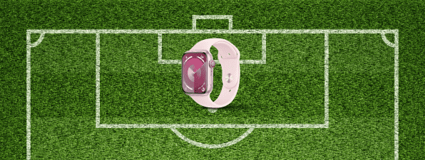 a pink smart watch on a green field