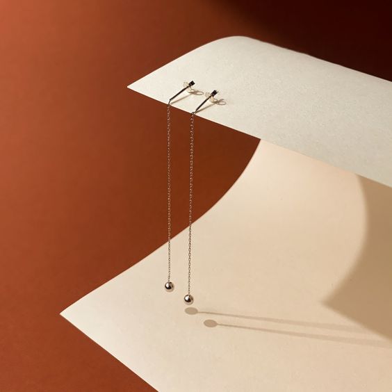 a pair of earrings on a piece of paper