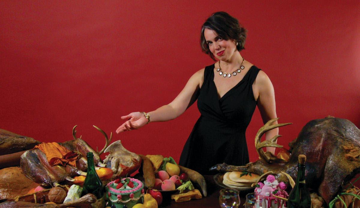 a woman standing next to a table full of food