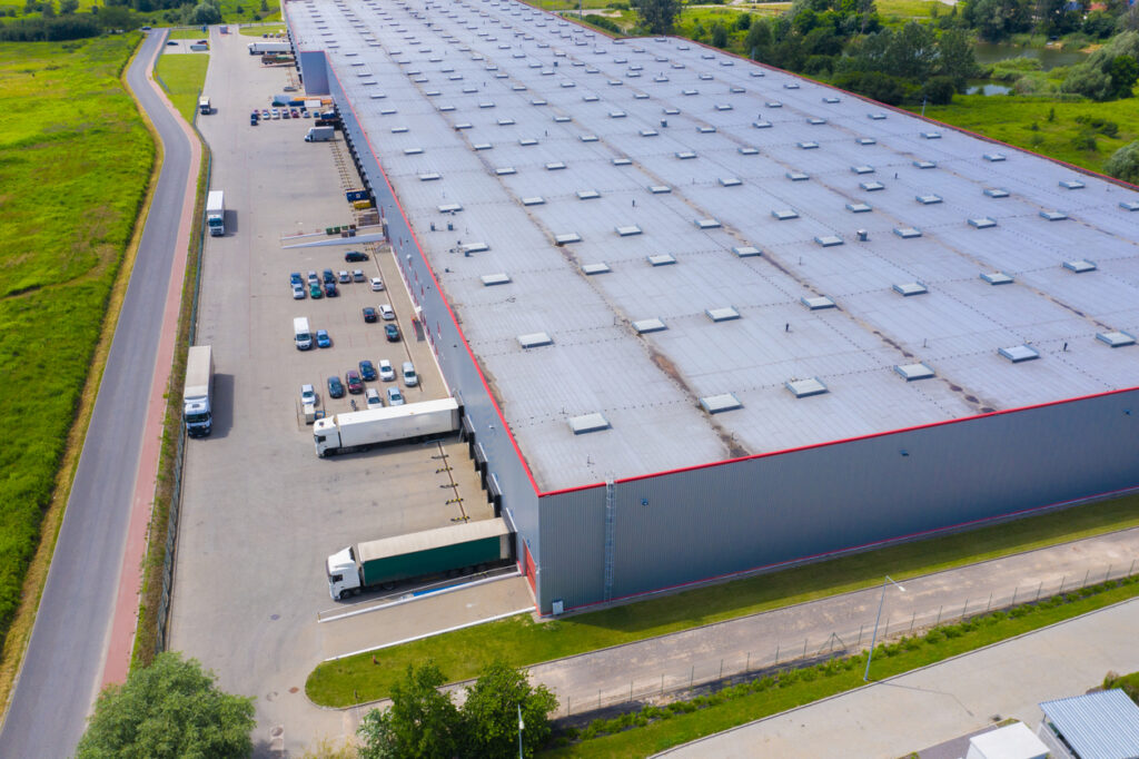 a large warehouse with many trucks parked in front of it