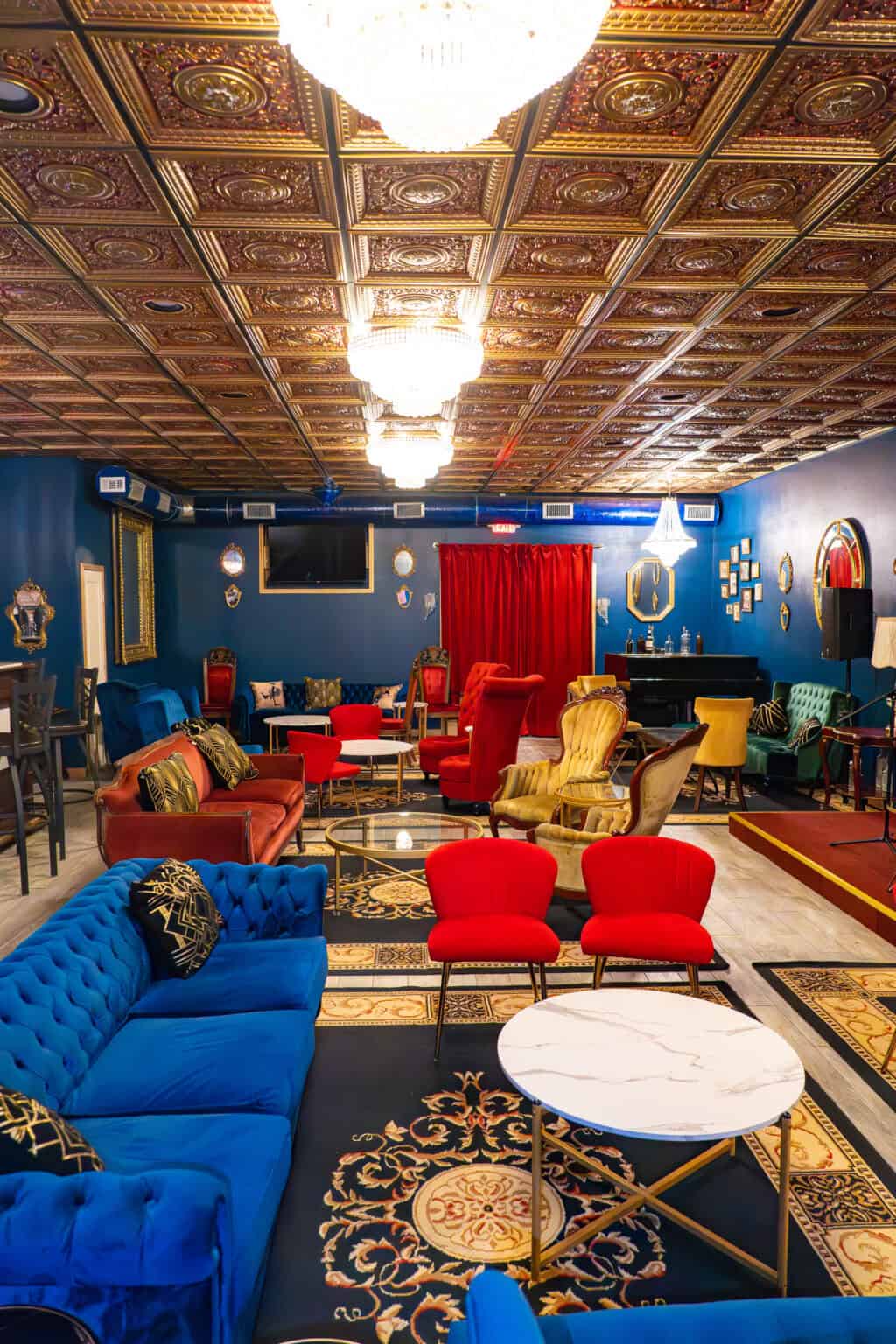 a room with a blue wall and red couches and a piano