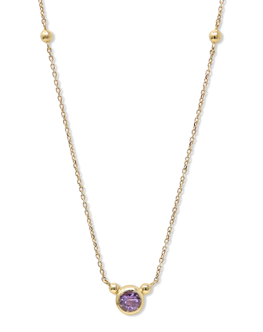 a gold chain with a purple stone