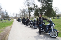 a group of men standing on motorcycles