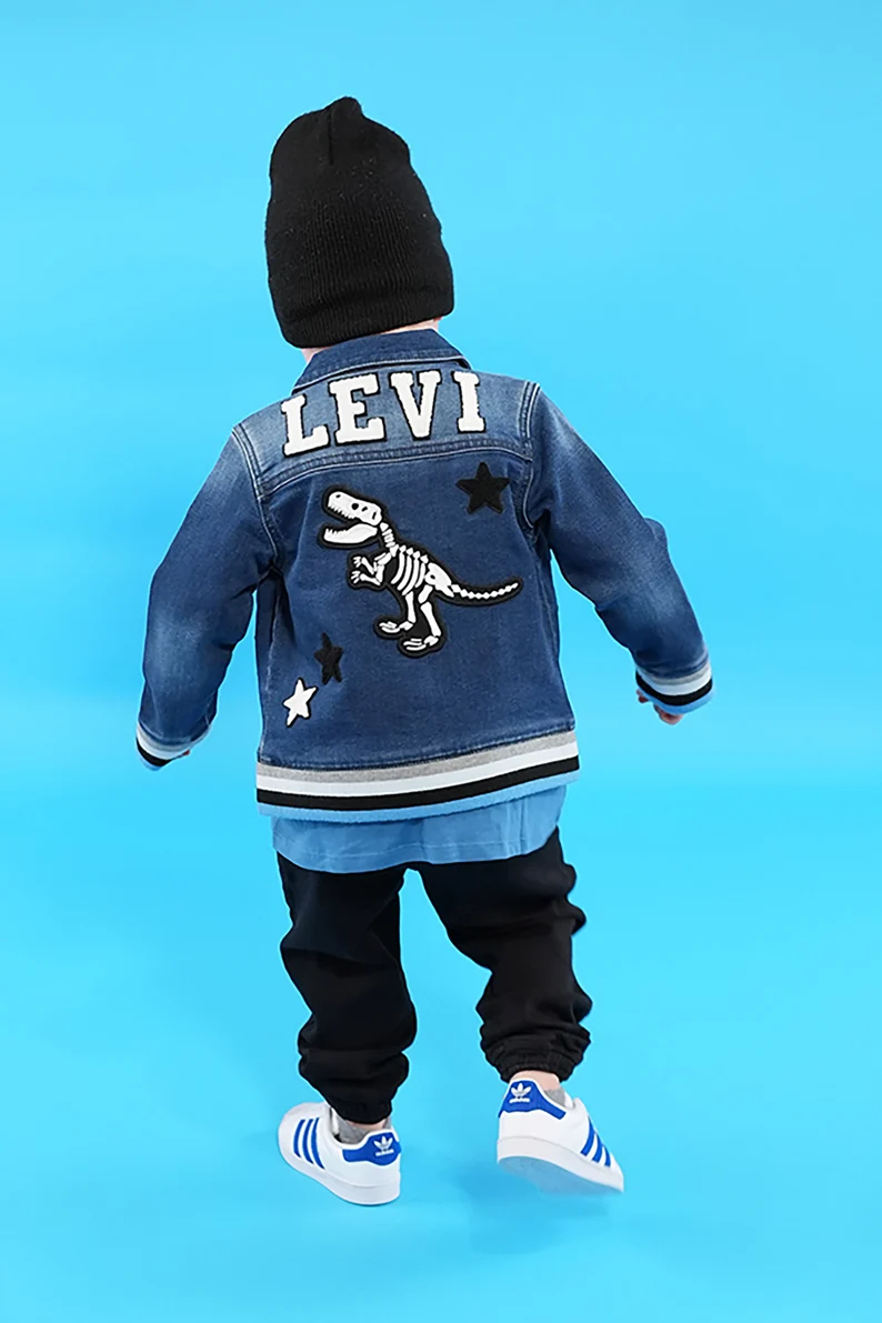 a child wearing a blue jacket and black hat