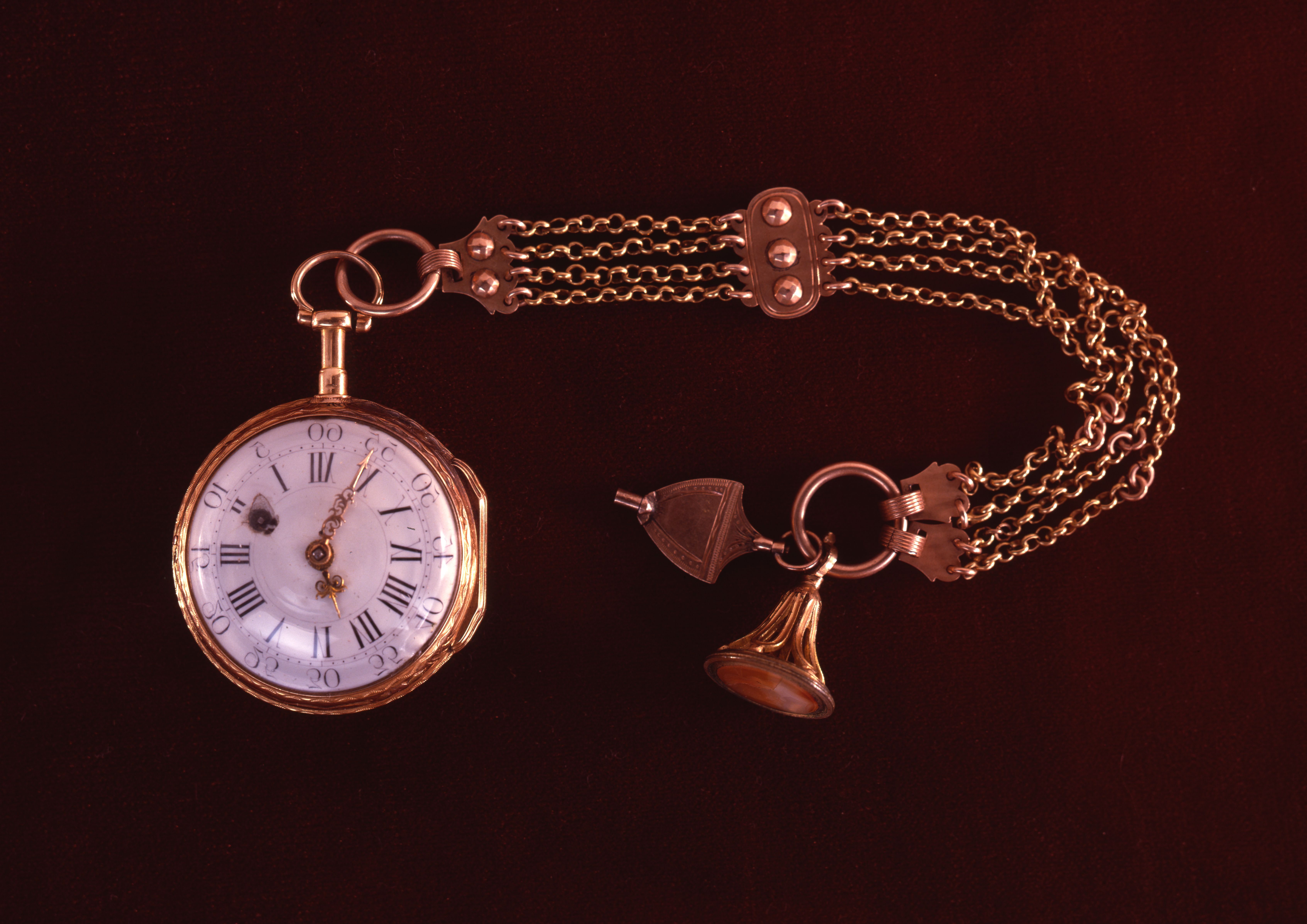 a gold watch with a bell on it