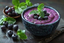 a bowl of blueberry smoothie with leaves