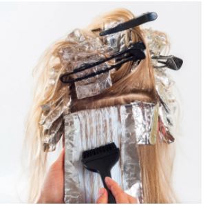 a person coloring hair with foil and hair clips