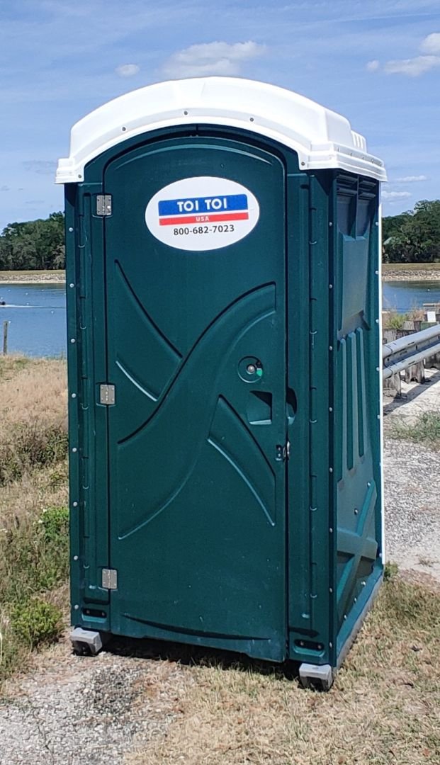 a portable toilet on a grass field